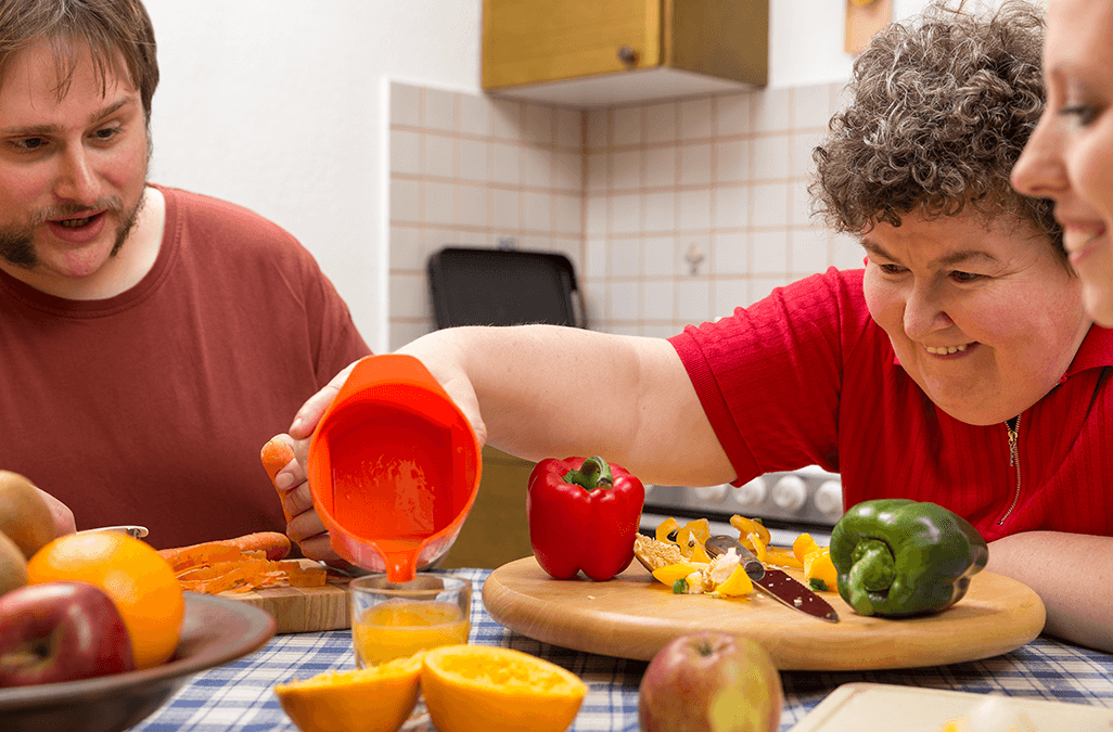 Photo of group home residents making orange juice