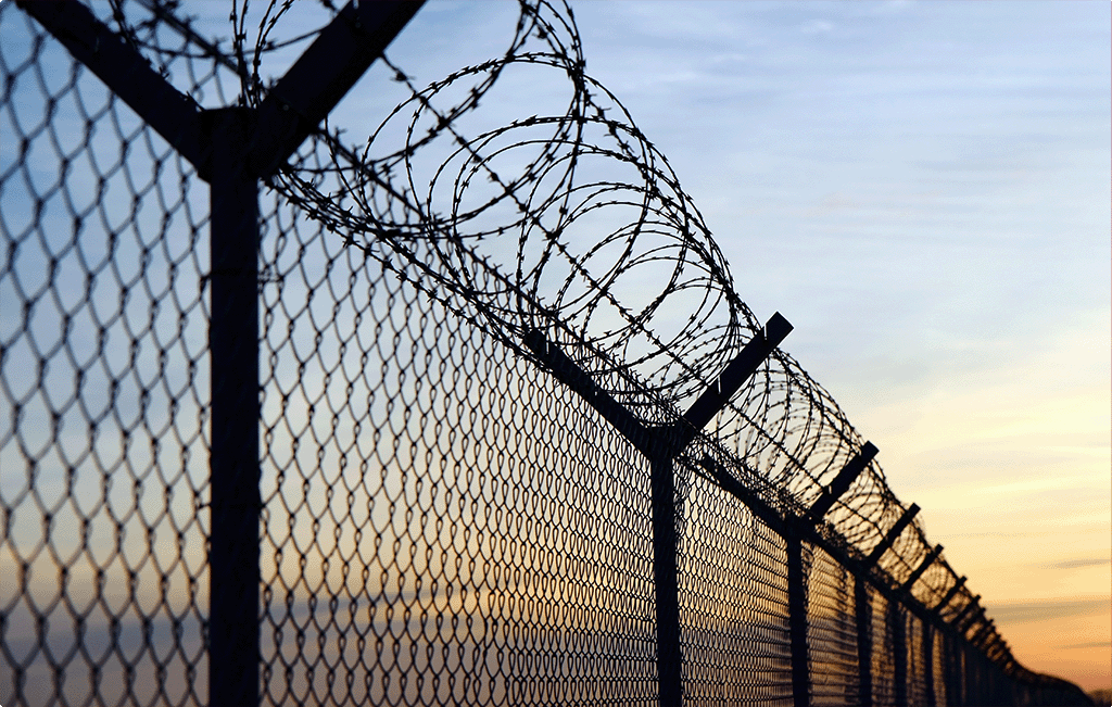 Prison fence at sunset