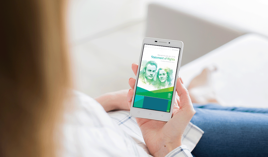Woman holding a phone with the Statement of Rights cover page on the screen.